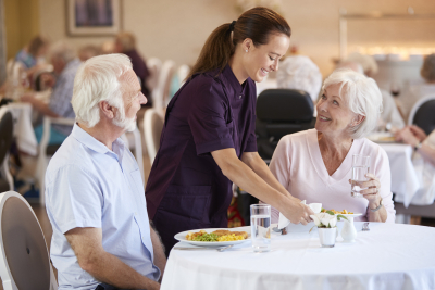 senior couple being served with meal