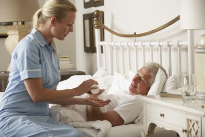 caregiver giving medicine at senior man